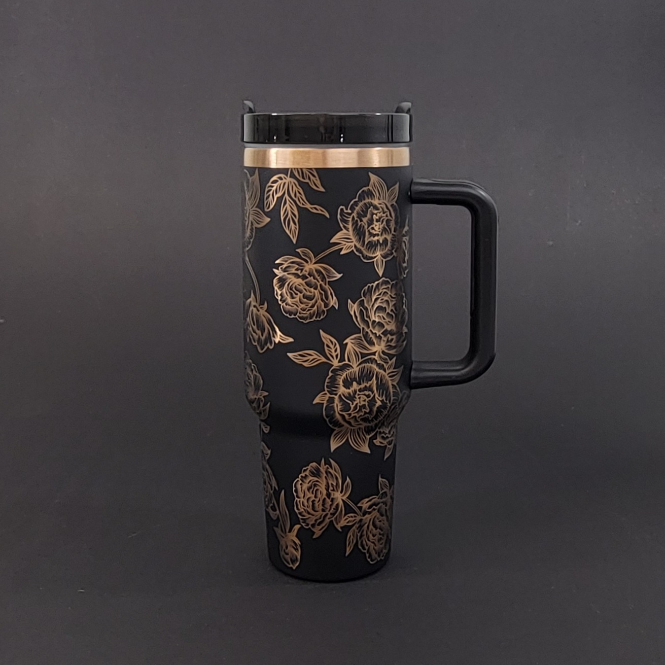 black tumbler with copper undertones laser engraved with intertwined peonies